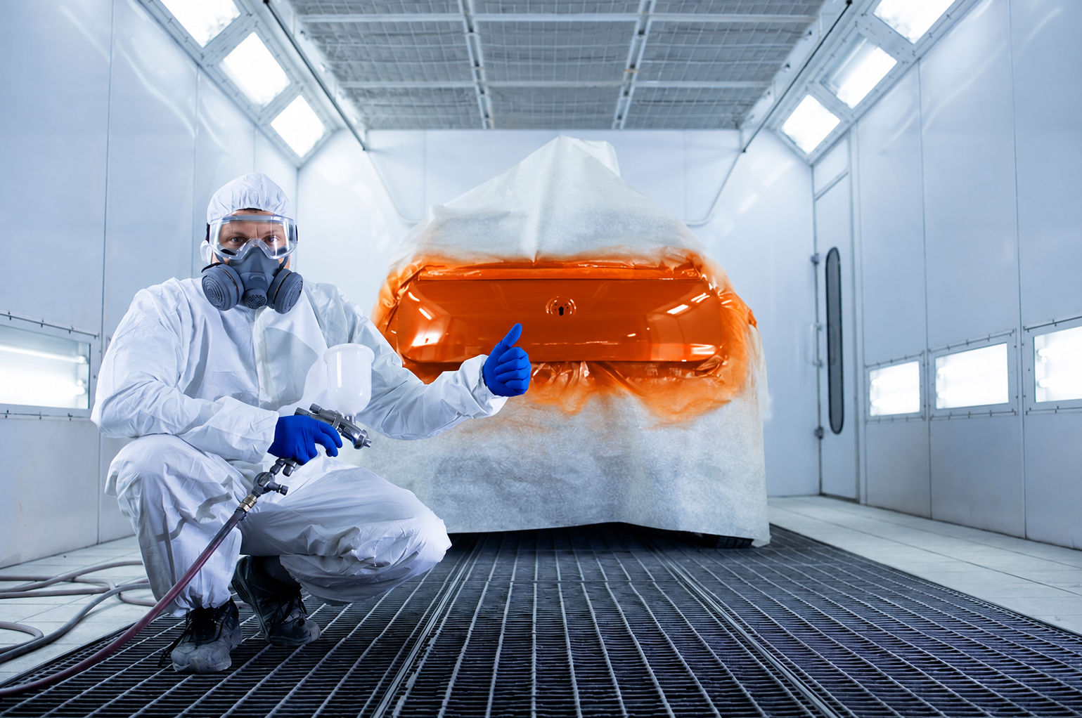 Autosicura verniciatore ricolora auto Un verniciatore autosicura in pausa mentre ricolora un'auto in arancione